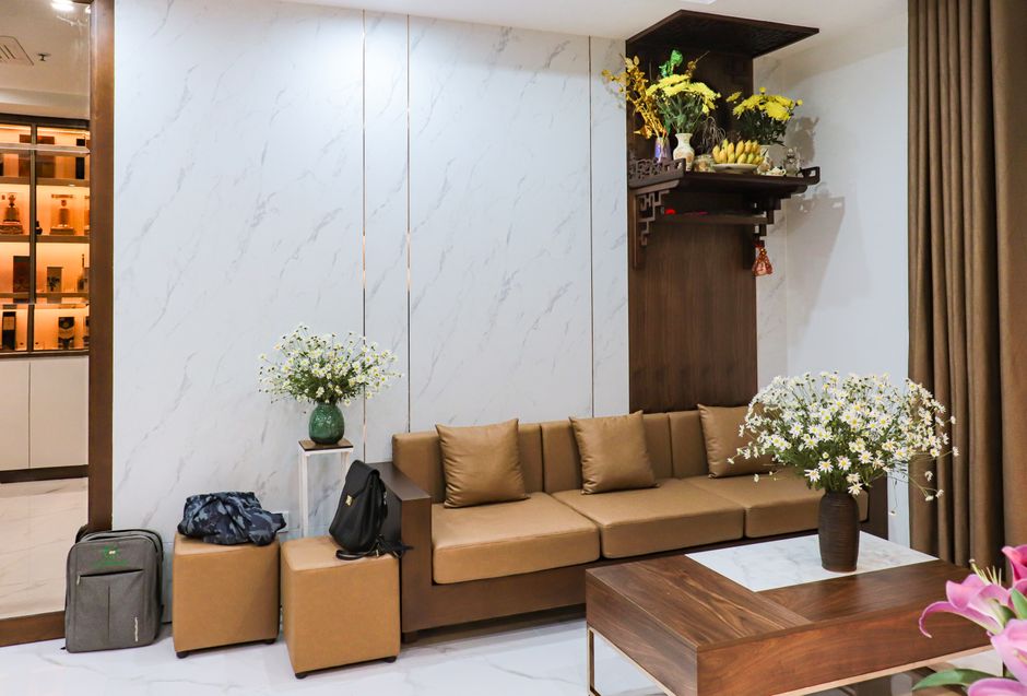 Stylish modern living room featuring brown furniture, decorative flowers, and elegant minimalistic design.